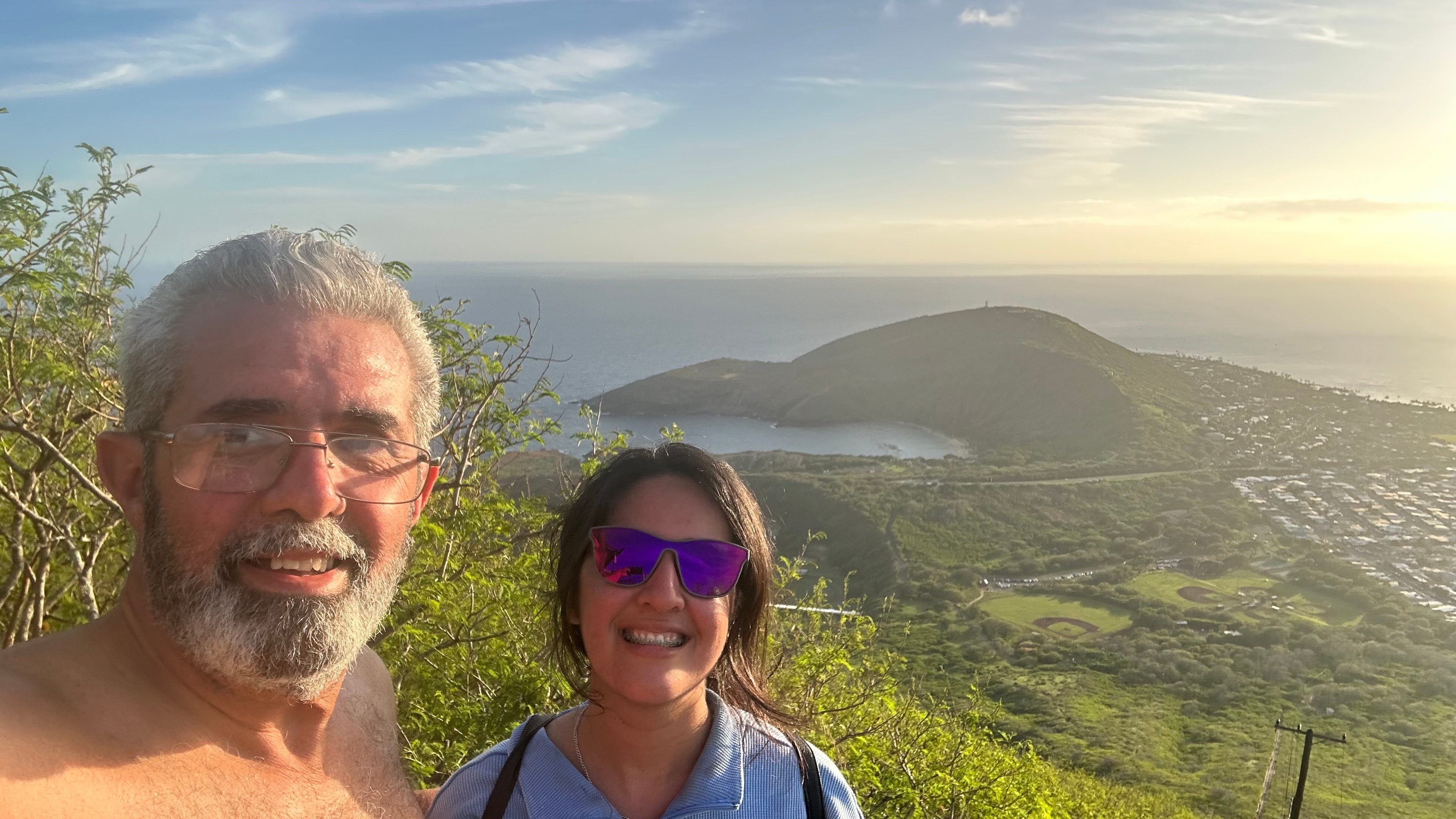 Luis and Priscilla smiling at the top of Koko Head with Oahu stretching out behind them